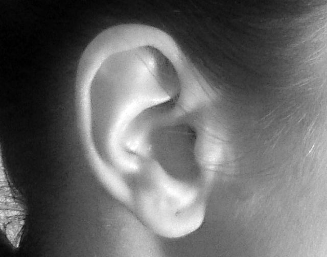 A photo of a human ear with a hole for an earring.